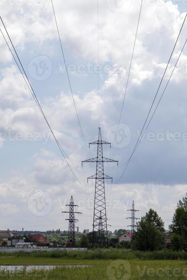 Hochspannungsmast. Stromleitungen und Strommasten an einem sonnigen Tag mit kreisförmigen Wolken am blauen Himmel. Hochspannungsleitung unterstützt. sie haben eine komplexe stahlkonstruktion. foto