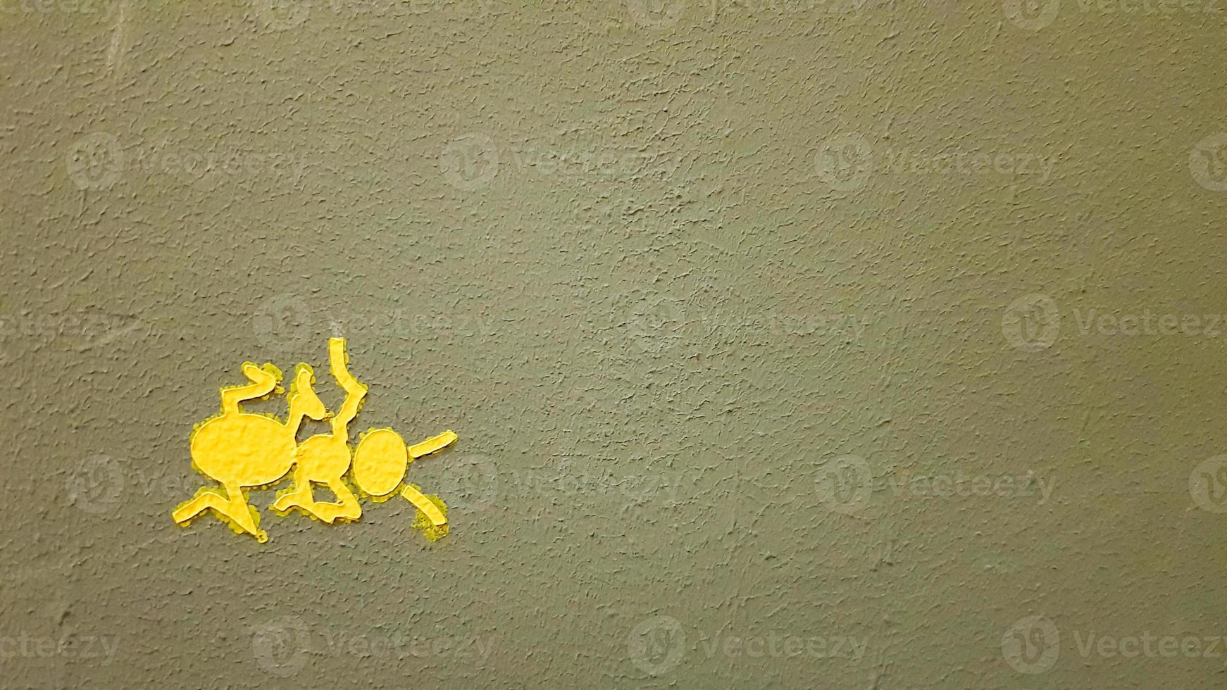 Gelb gemalte Ameise an einer grauen Wand. Ameise, die eine Wand klettert. bunte Ameisenhintergründe. lokale Künstler schmücken die Wände der Straßen. foto