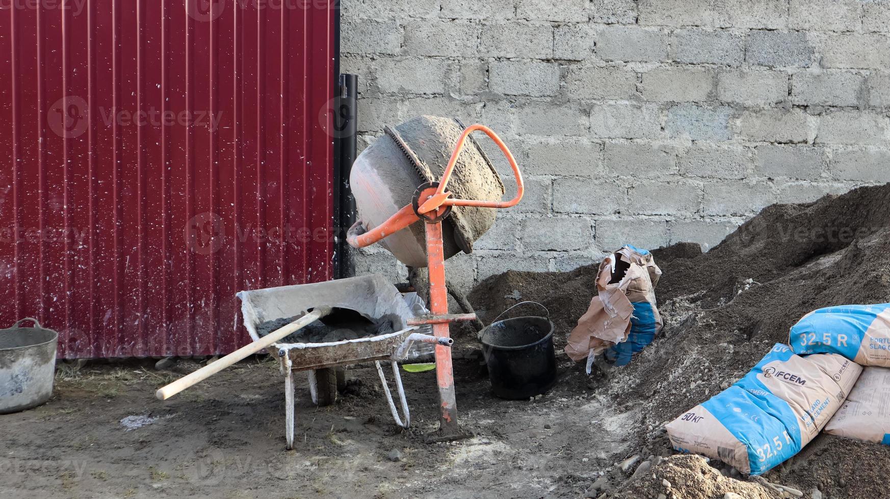 Schwerkraft mobiler Betonmischer mit selbstentladender oranger Farbe bereitet Zementmörtel vor. mobile Baumaschine zur Herstellung von Betonmischungen. Mischen von Massenprodukten. foto