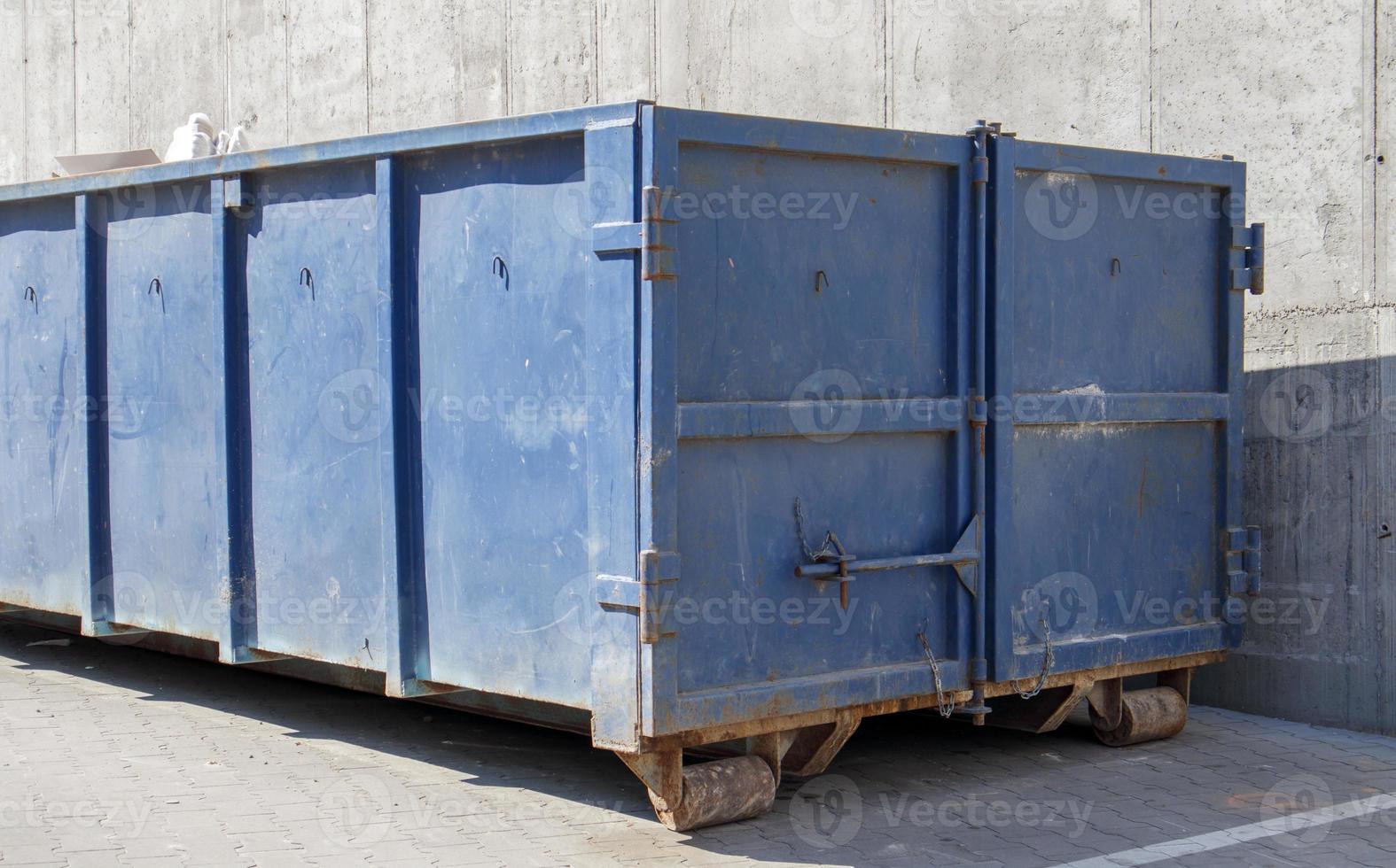 Metall haltbarer blauer industrieller Mülleimer für Müll im Freien auf der Baustelle. großer Abfallkorb für Haus- oder Gewerbemüll. ein Haufen Müll. foto
