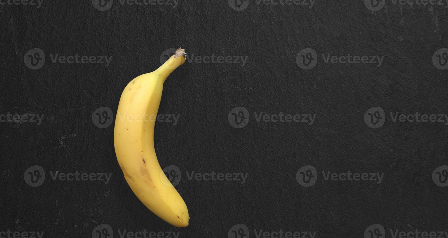 Draufsicht isoliert frische gelbe Banane auf dunklem Tisch isoliert. Kopierraum für Text hinzugefügt. foto