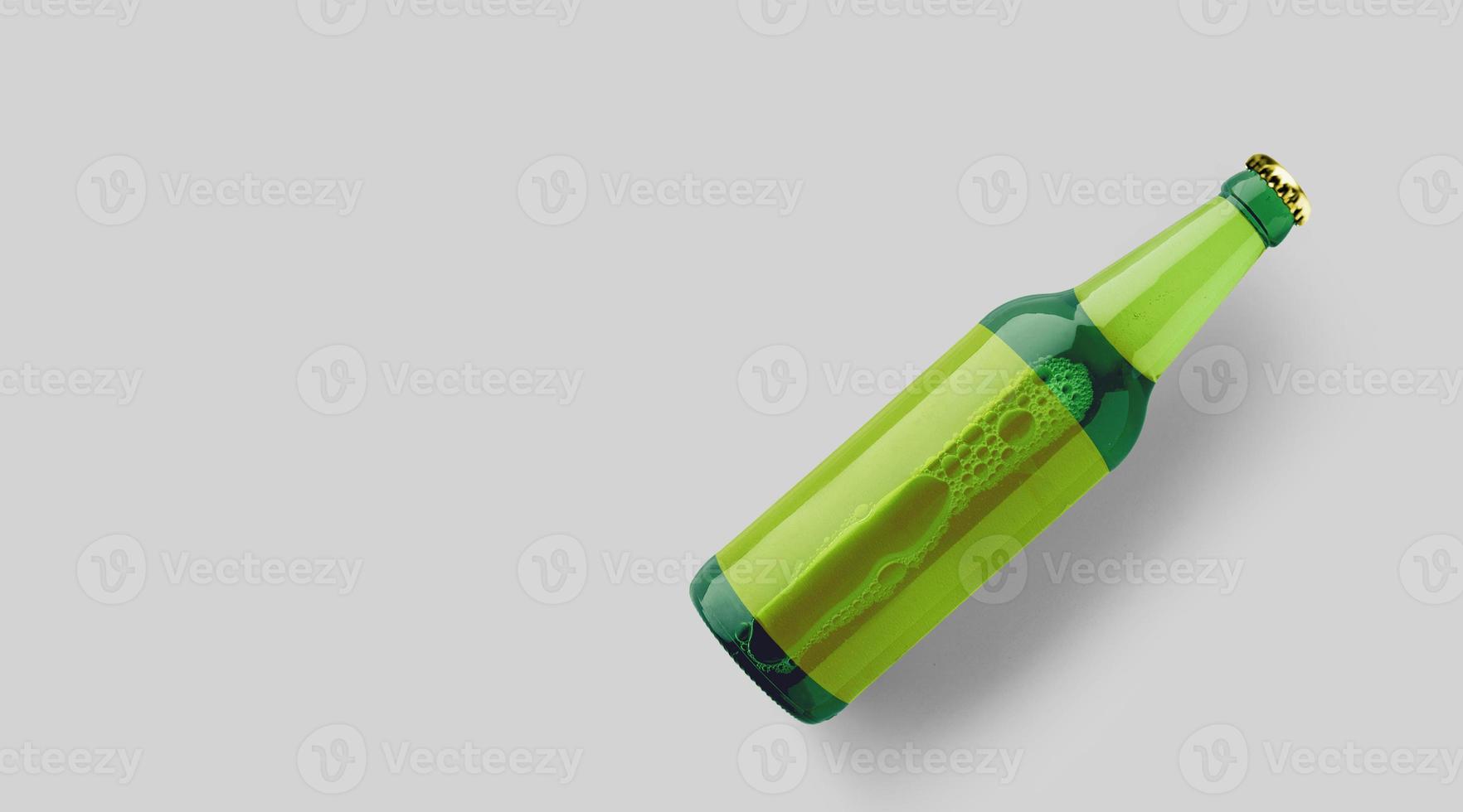 Top-up-Ansicht grüne Bierflasche mit leerer gelber Vorlage auf grauem Hintergrund isoliert. Bier-Fiesta-Konzept. foto