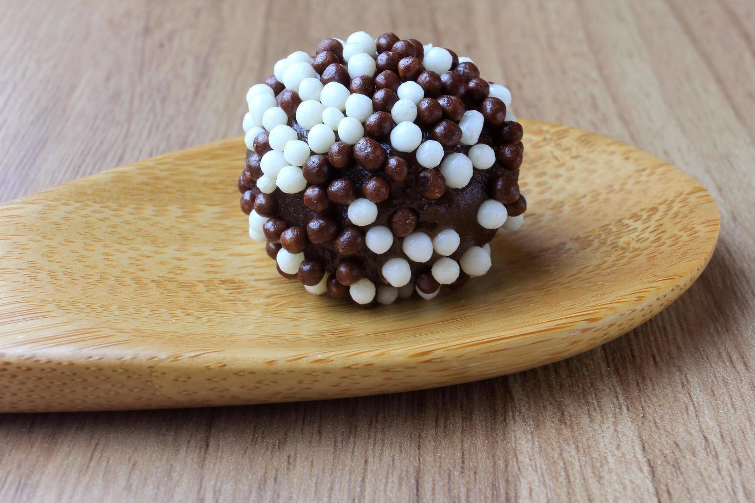 Brigadeiro, Brigadegeneral, süße Schokolade typisch für die brasilianische Küche mit Partikeln bedeckt, in einem hölzernen Hintergrund. foto