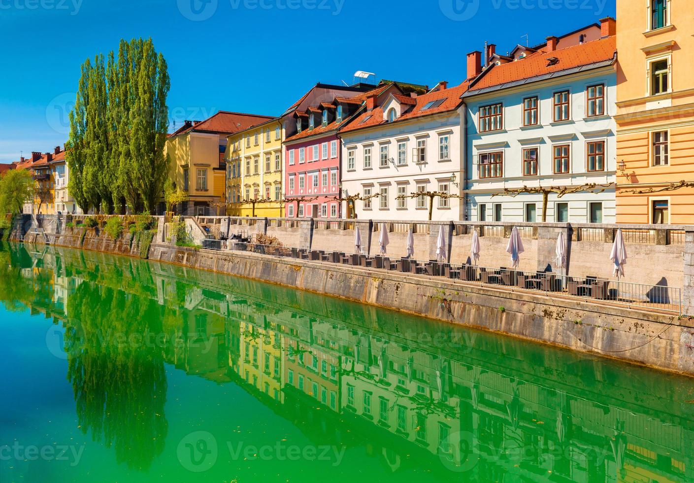 Blick auf den Fluss Ljubljanica im Zentrum von Ljubljana. bunte historische Gebäude spiegeln sich im Wasser foto
