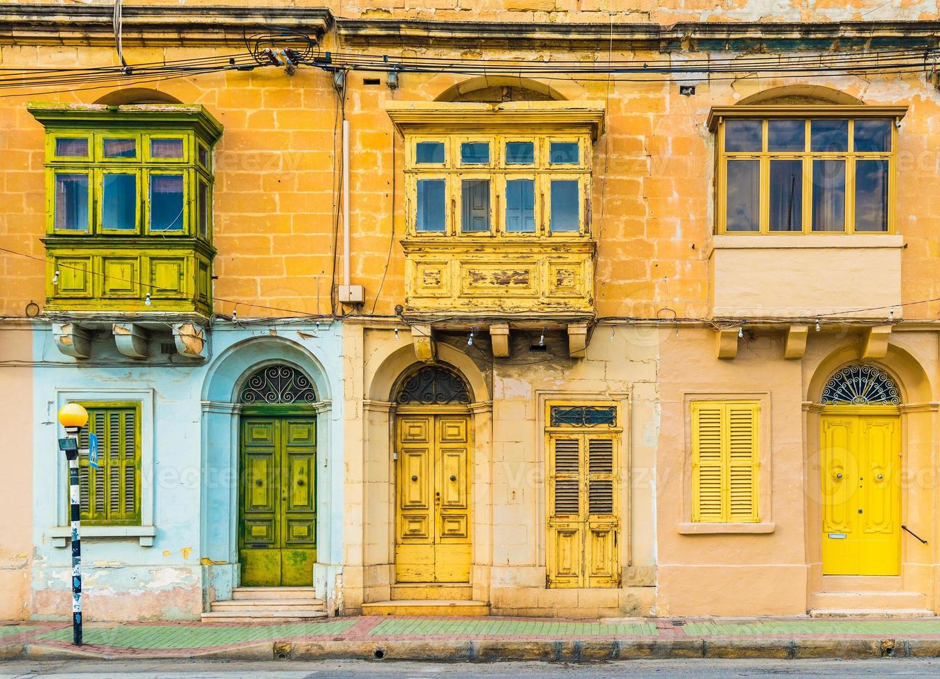 Malta, Valletta - Fassade eines Wohnhauses mit traditionellen maltesischen Balkonen. Haus aus gelben Ziegeln in der Straße von Malta. foto