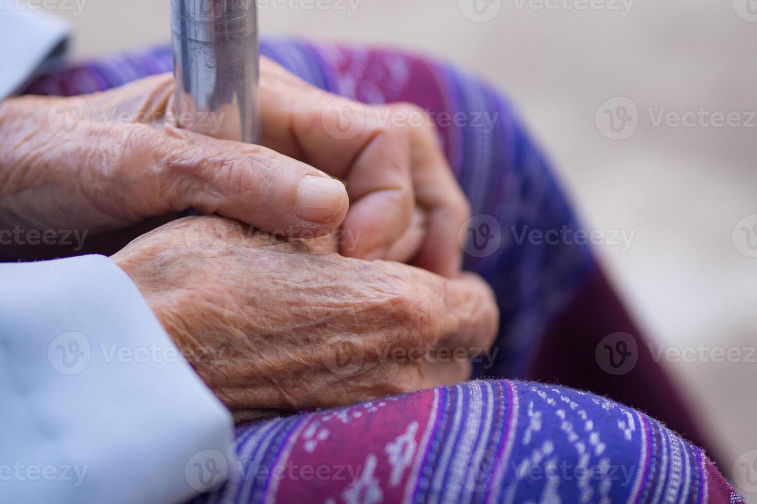 Nahansicht von Hände Alten Frau halten Gehen Stock. Fokus auf Hände faltig Haut. Raum zum Text. Konzept von alt Menschen und Gesundheitswesen foto