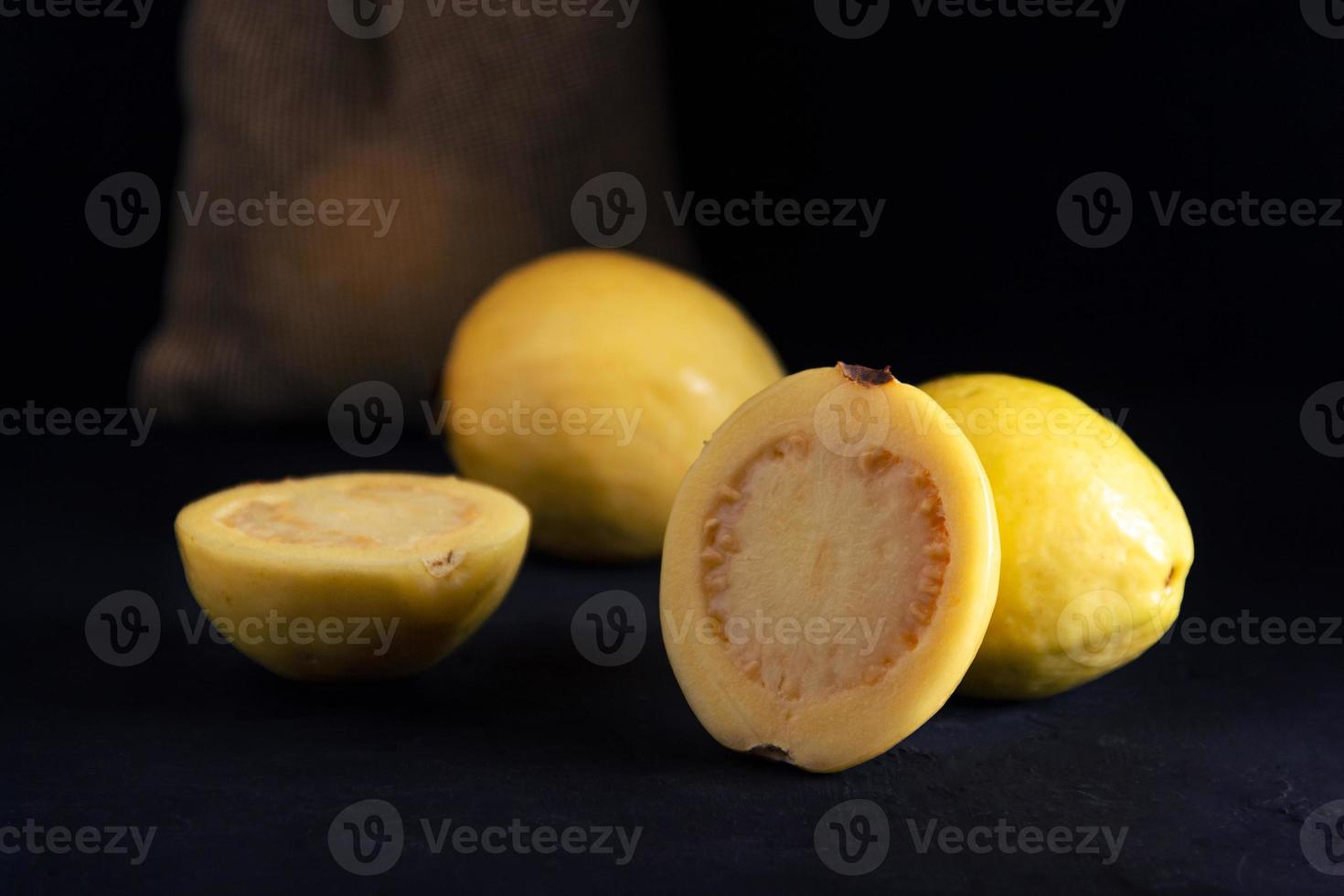 gelbe Guave auf schwarzem Hintergrund, Stilleben. gesunde Ernährung foto