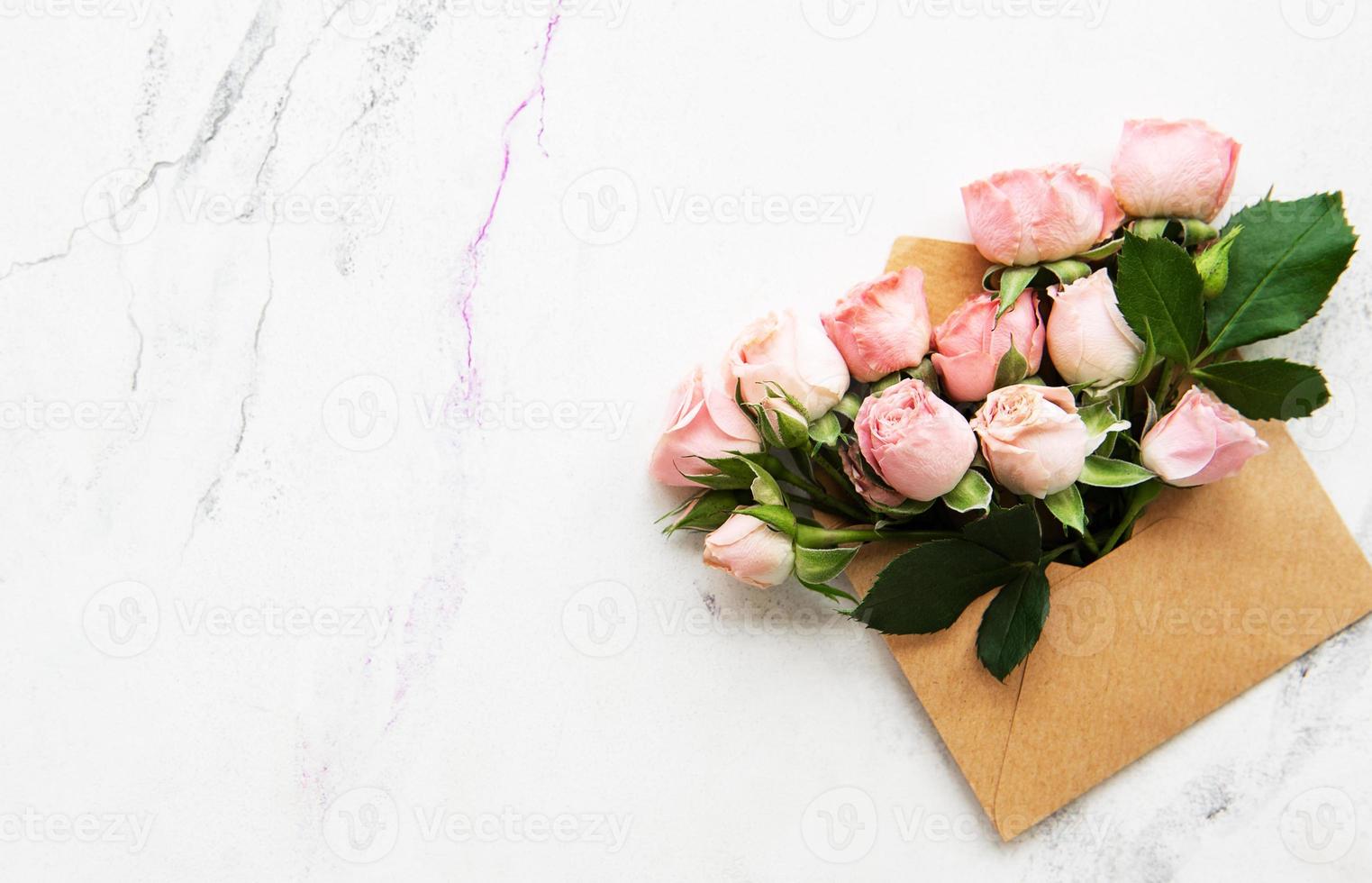 Umschlag und rosa Rosen foto
