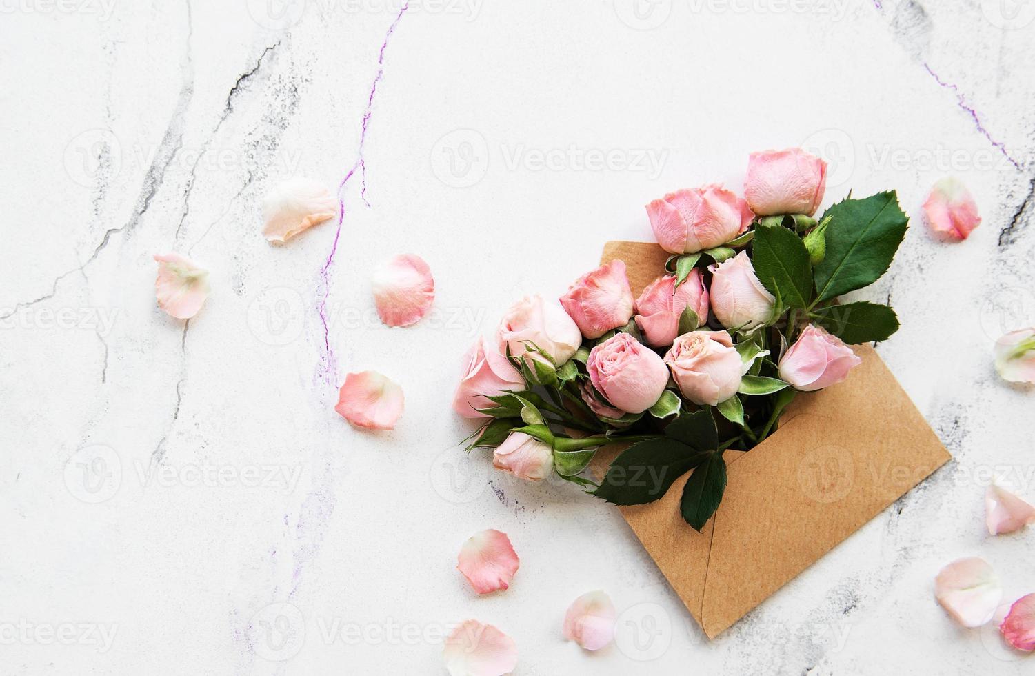 Umschlag und rosa Rosen foto