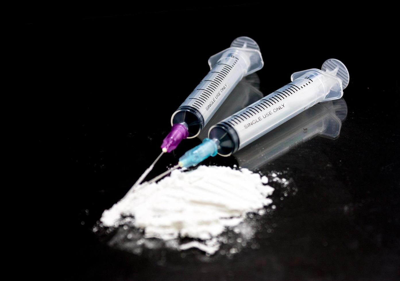 Heroinspritze und gekochtes Heroin auf schwarzem Hintergrund. foto
