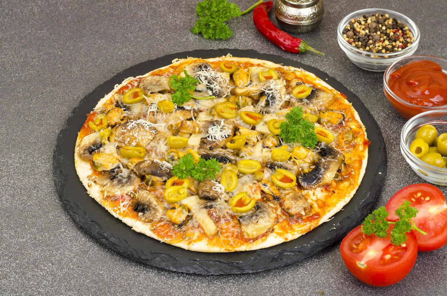 Pizza mit Muscheln, Pilzen, grünen Oliven. Studiofoto. foto