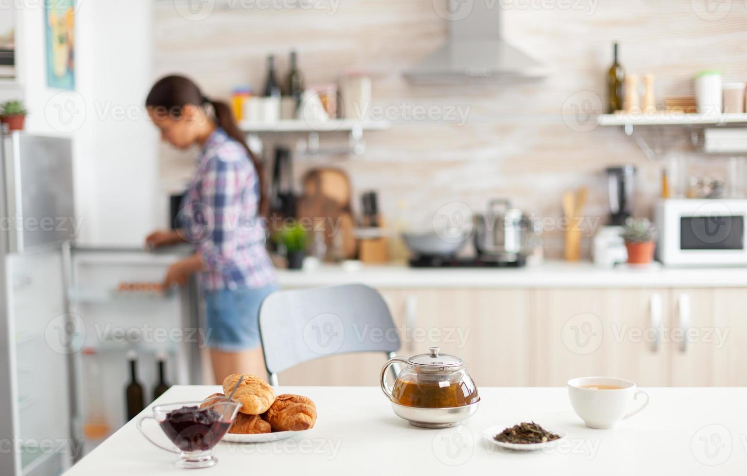 Frau schaut in den Kühlschrank foto