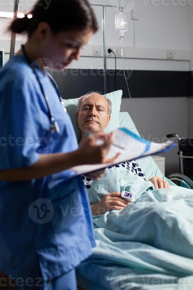 medizinische Krankenschwester in Peelings, die Notizen auf der Zwischenablage macht foto