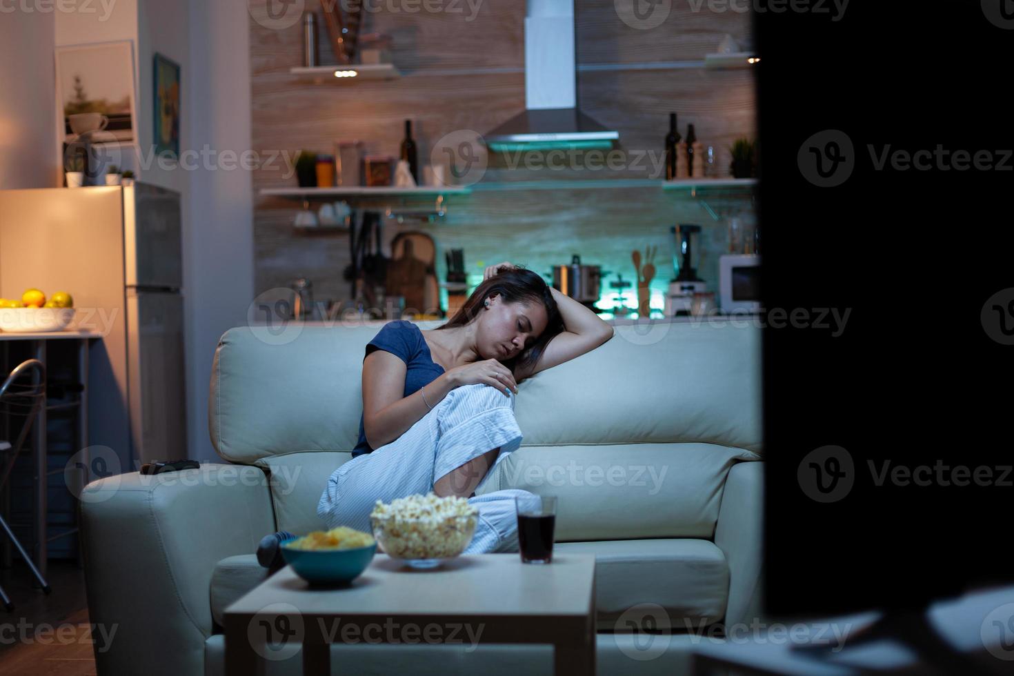 Frau schläft auf einem Sofa vor dem Fernseher foto