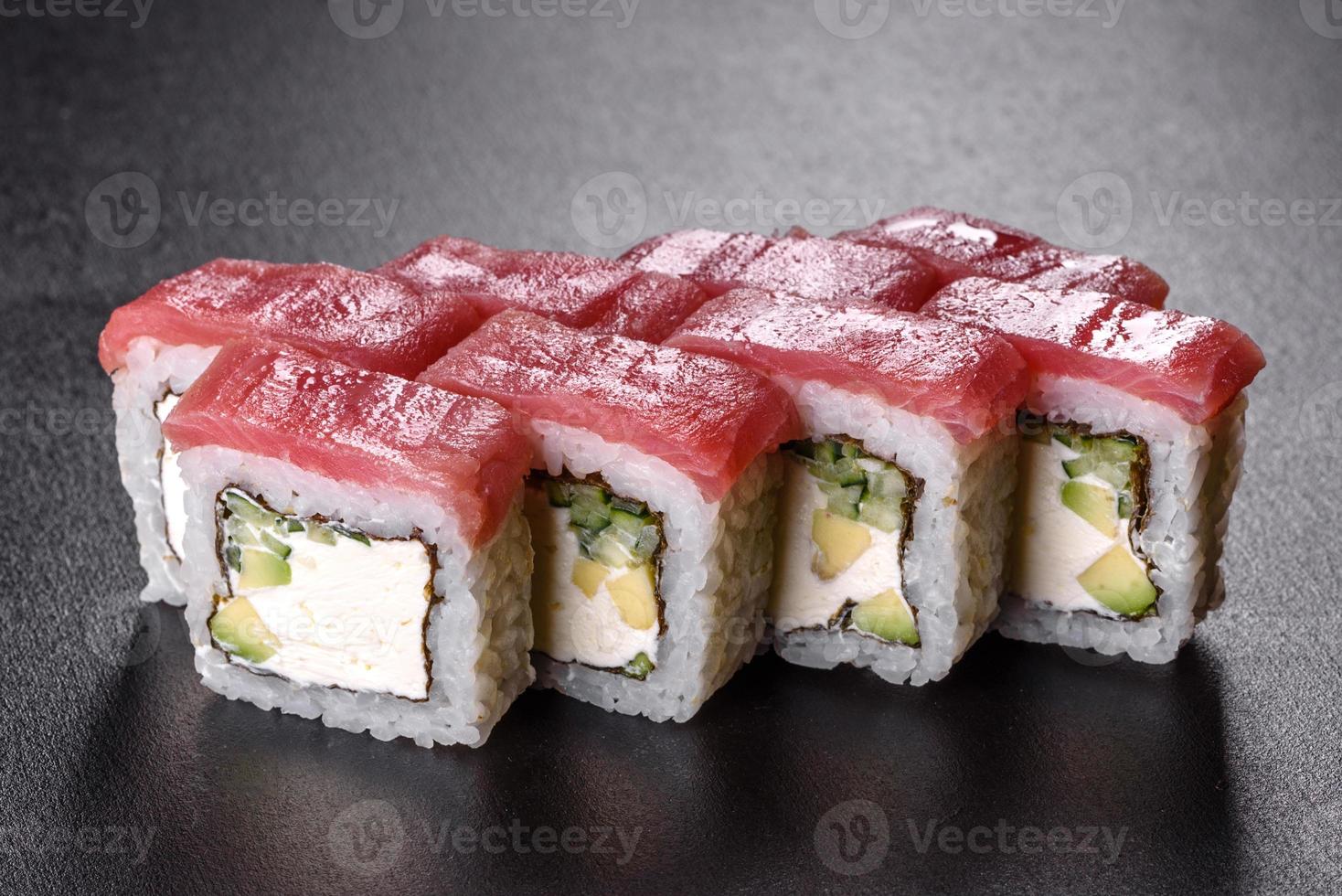 traditionelle köstliche frische Sushi-Rolle auf schwarzem Hintergrund foto