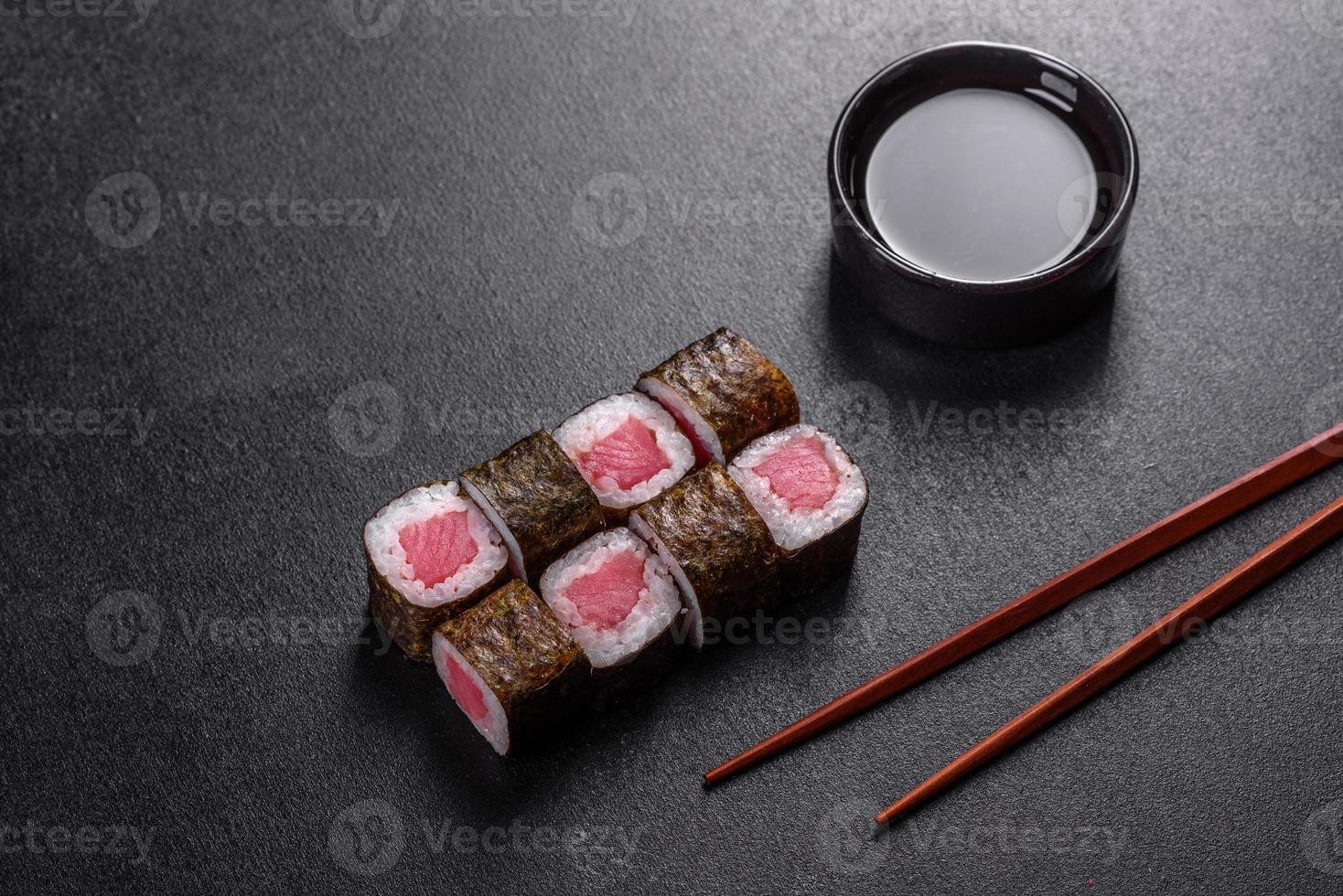 traditionelle köstliche frische Sushi-Rolle auf schwarzem Hintergrund foto