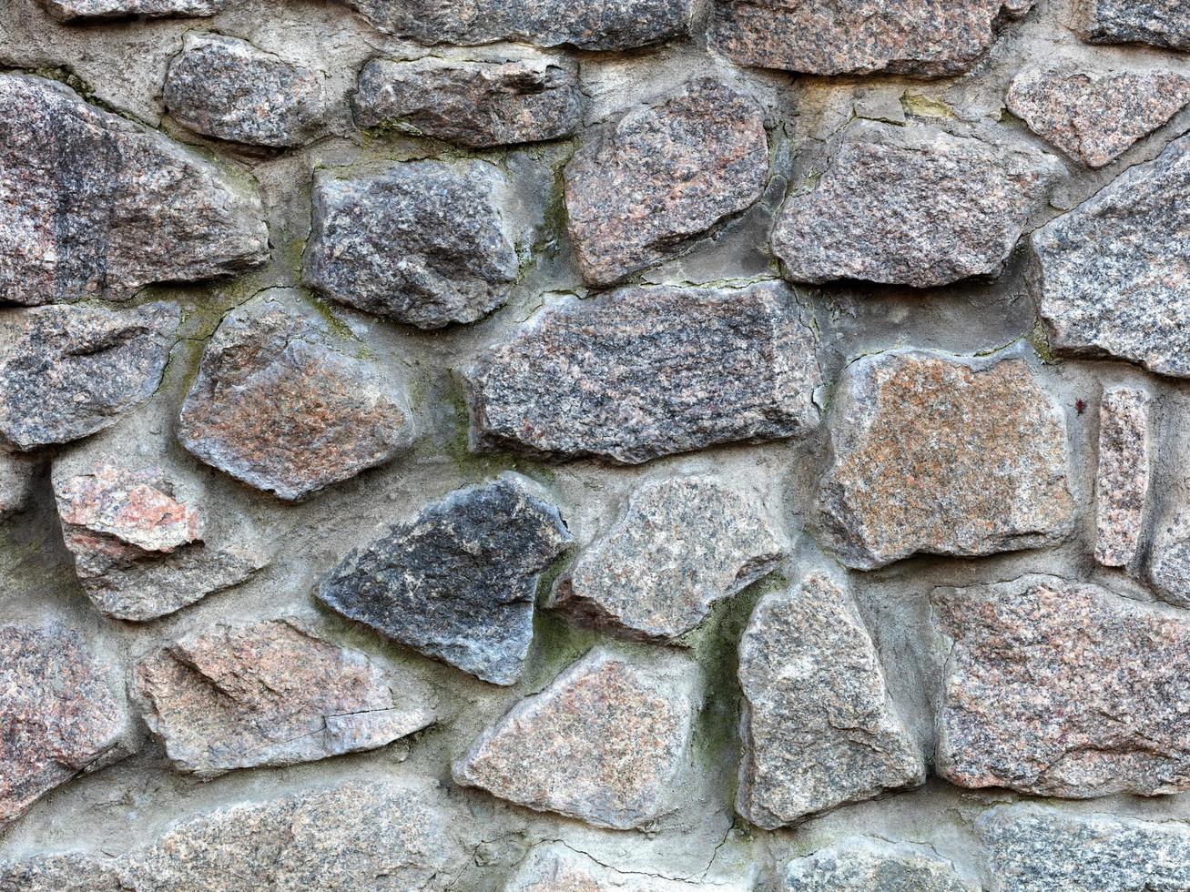 Steinmauer aus einer großen Granit-Kopfsteinpflaster-Nahaufnahme foto