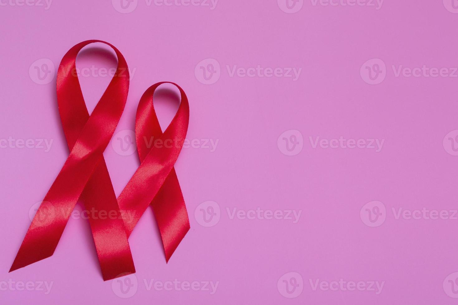 Draufsicht auf rosa Hintergrund mit rotem Bandkonzept 1. Dezember internationaler Aids-Tagesnahaufnahme. foto