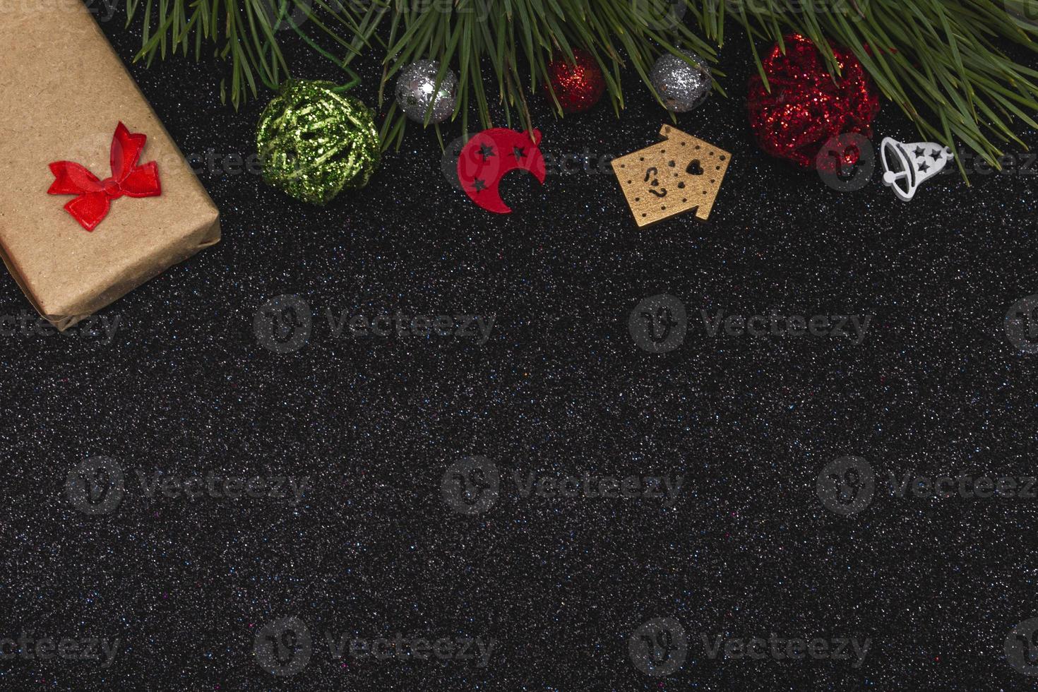 flache Draufsicht des neuen Jahresmodells auf schwarzem glänzendem Hintergrund mit Elementen des neuen Jahres und Kiefernzweig. Platz kopieren foto