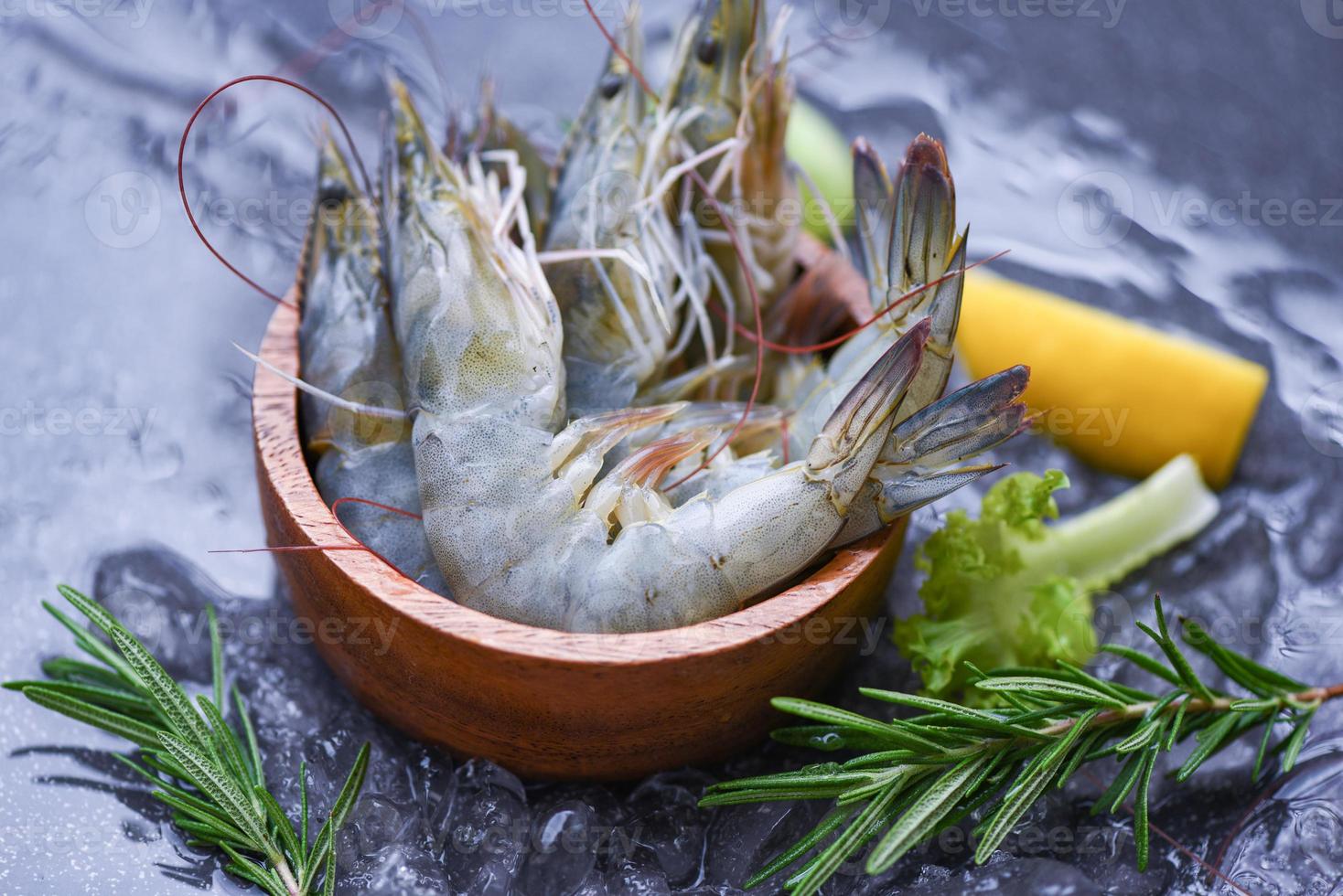 frische Garnelen auf Schüssel mit Rosmarinzutaten Kräuter und Gewürze zum Kochen von Meeresfrüchten - rohe Garnelen Garnelen auf Eis gefroren im Fischrestaurant foto