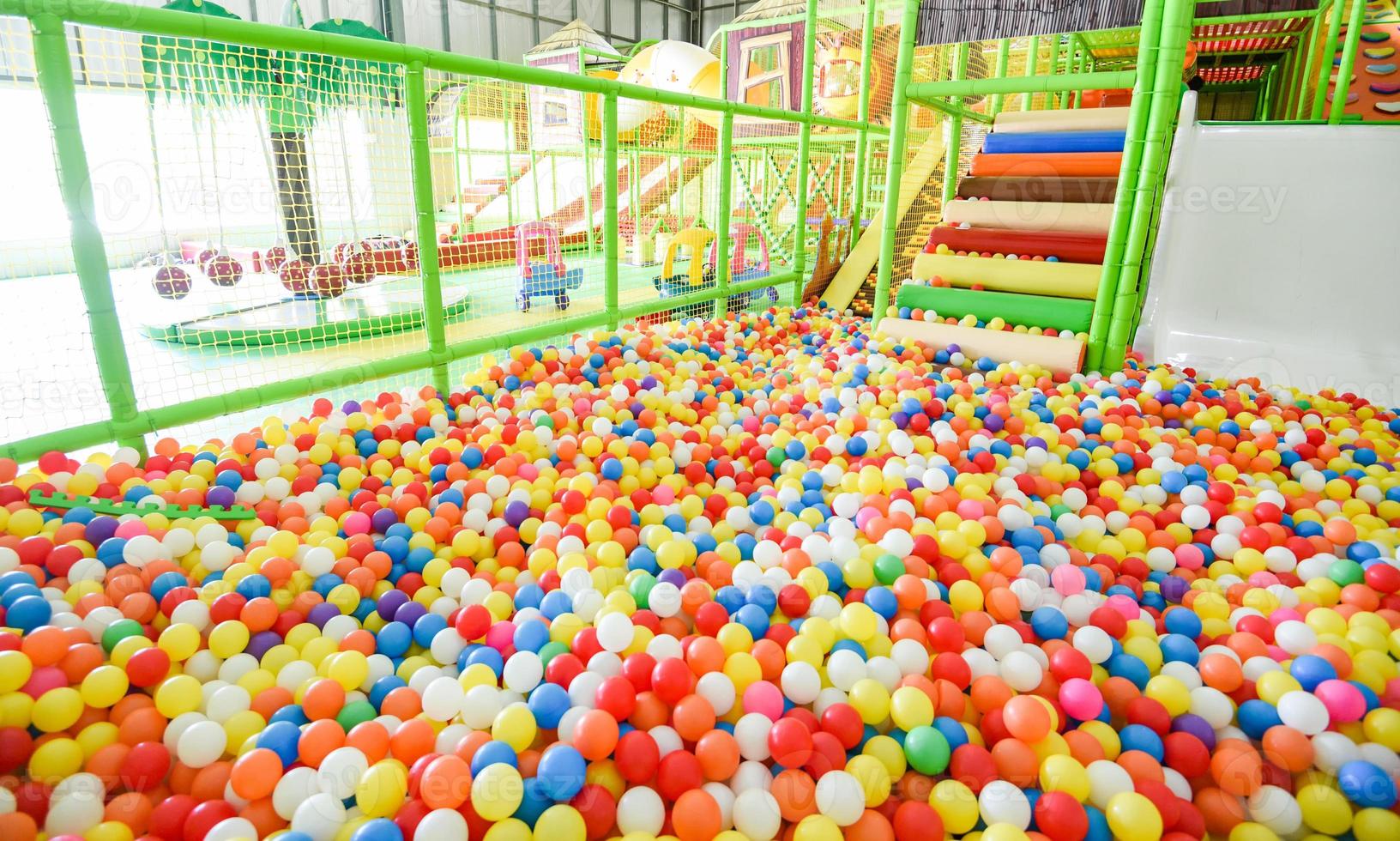 Kinderspielplatz drinnen im Vergnügungspark mit bunten Bällen zum Spielen - im schönen Kinderspielball aus farbigem Kunststoff des Spielzimmers foto