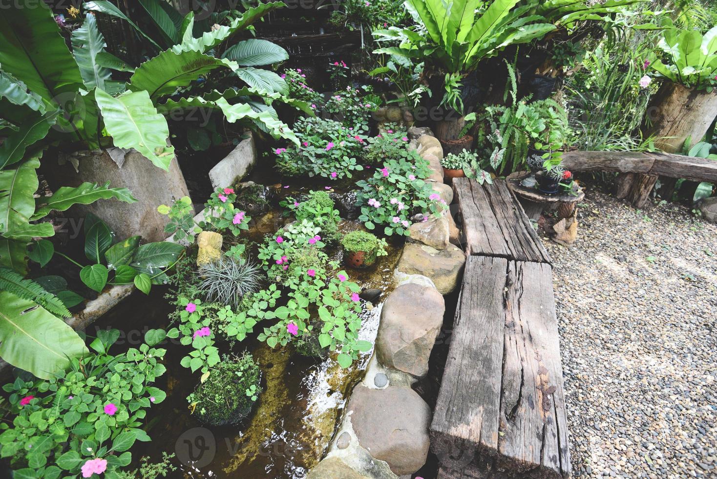 Wasserbach oder kleiner Wasserfall schmücken Vorgarten - Naturgarten mit Pflanzenbaumblüten im asiatischen mit Teichpark foto