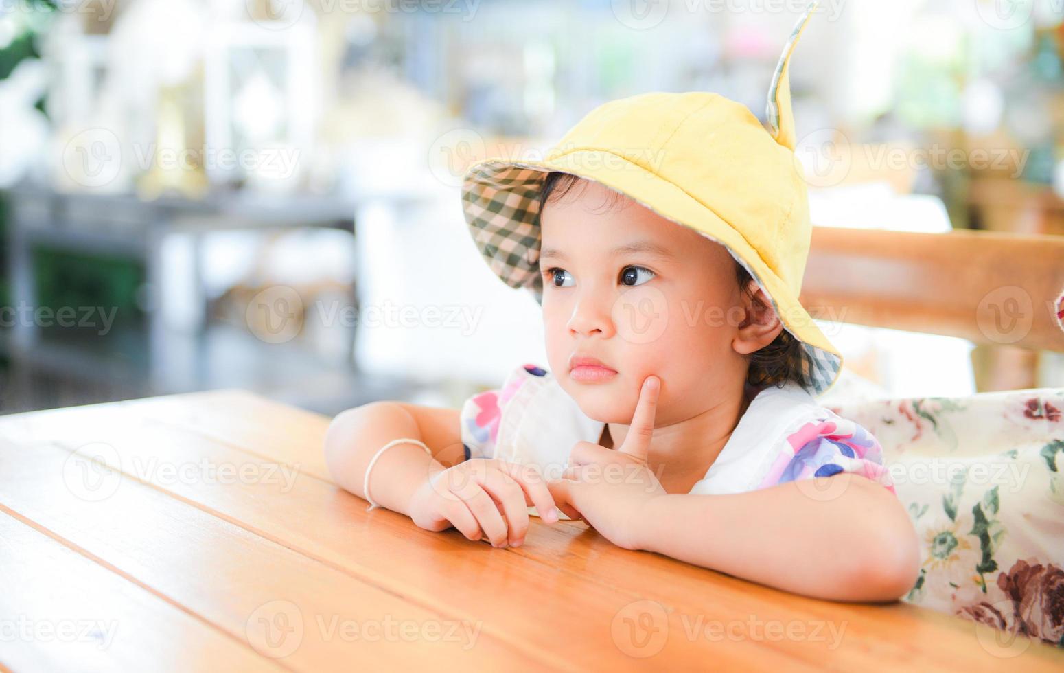 kleines asiatisches Kindermädchen, süße Mädchenkinder, die Esstisch spielen. foto