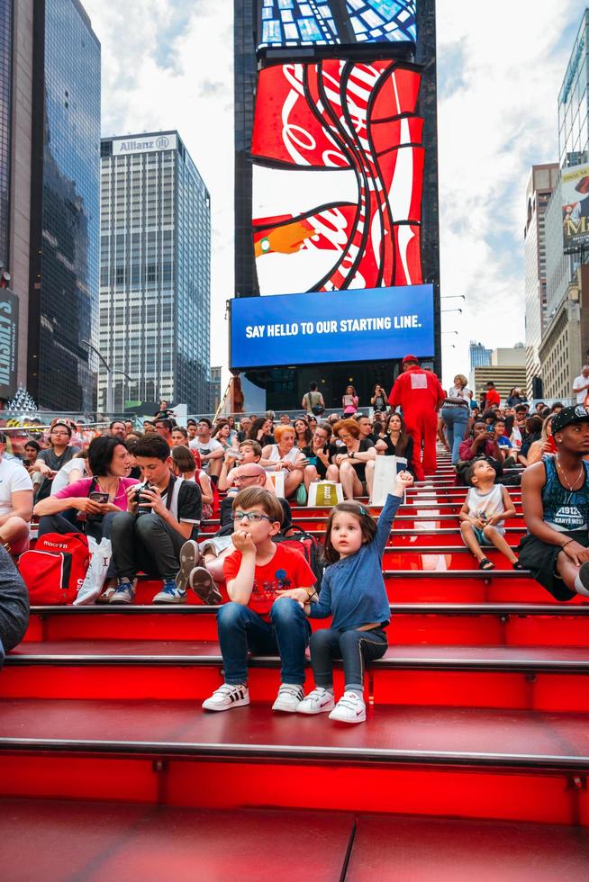 New York City, USA - 21. Juni 2016. Kinder sitzen über der berühmten Treppe des Times Square, ikonisches Symbol von New York City foto