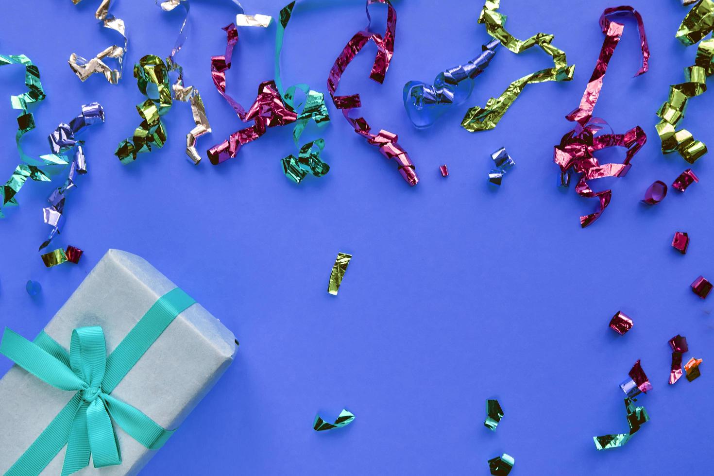 Weihnachtskomposition. Geschenkbox mit Band- und Konfettidekorationen auf buntem Hintergrund des Pastellpapiers. Weihnachten, Winter, Neujahrsfeierkonzept. flach legen, Ansicht von oben, Platz kopieren foto