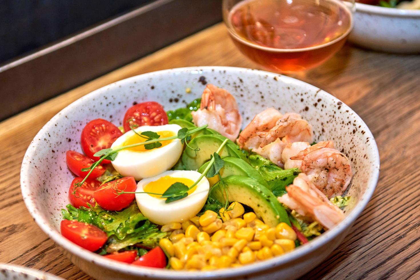 köstlicher Garnelensalat im Restaurant auf einem Holztisch. leckere Meeresfrüchte mit Bier im Café oder Pub-Menü. foto