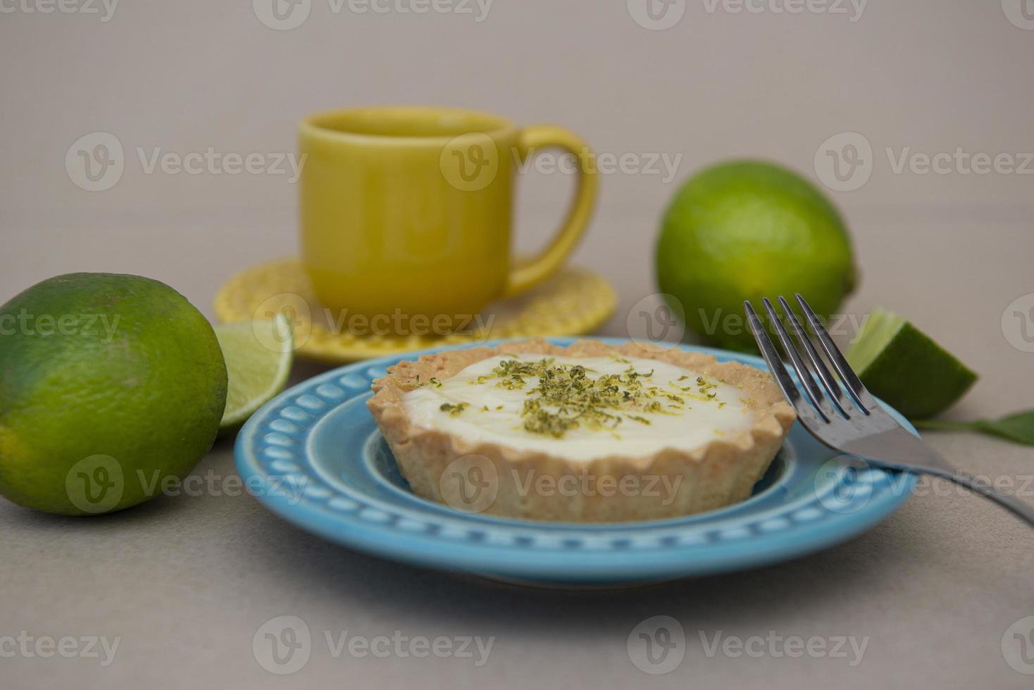 Seitenansicht der Zitronentarte auf Teller mit Zitronenscheiben auf dem Tisch. foto