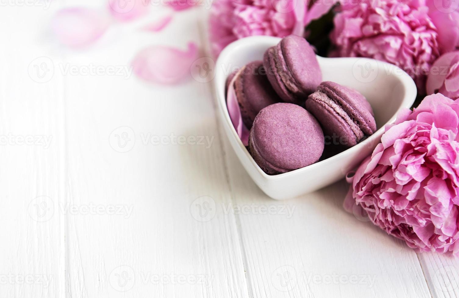 rosa Pfingstrosenblüten mit Macarons foto