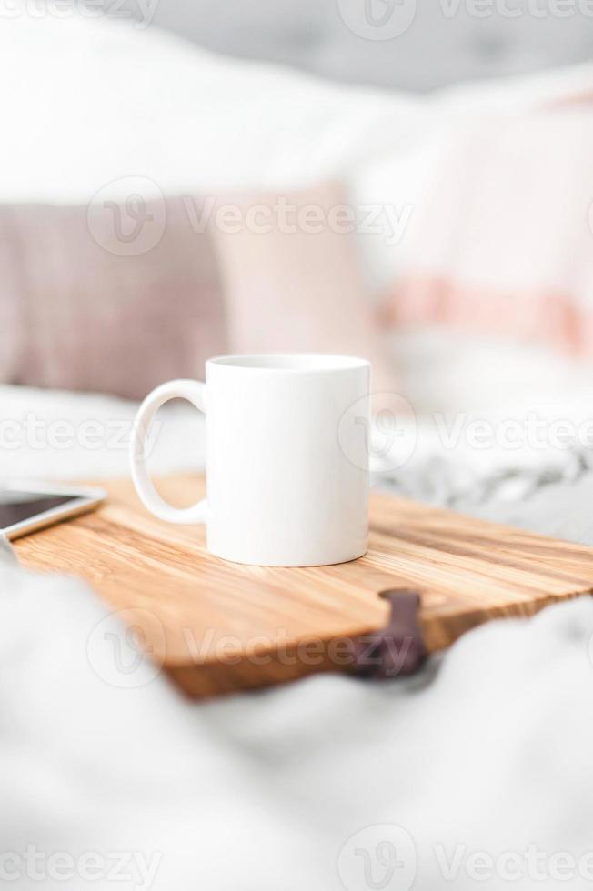 weiße Kaffeetasse auf Holztisch für Mock-up-Set isoliertes glasiges Humpen-Design auf weiß foto