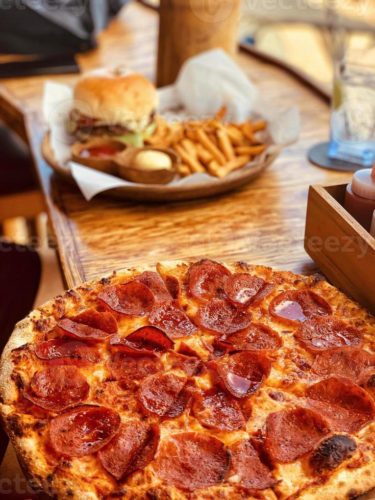 Pizza und Ding mit einem Hintergrund von Pommes frites und Getränken foto