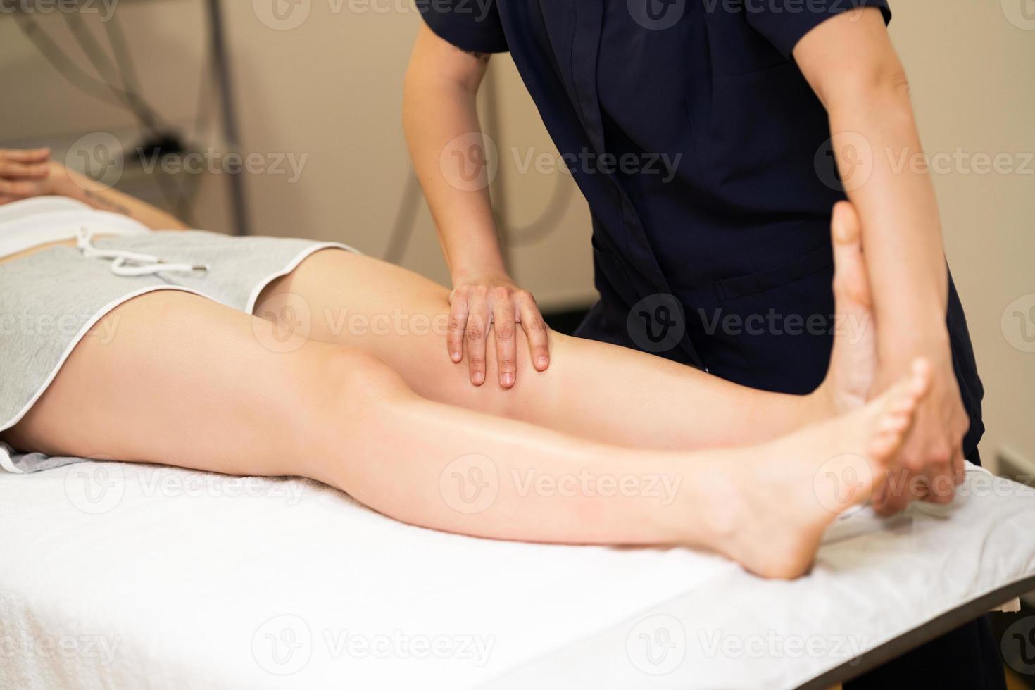 Physiotherapeutin inspiziert ihren Patienten in einem Physiotherapiezentrum. foto