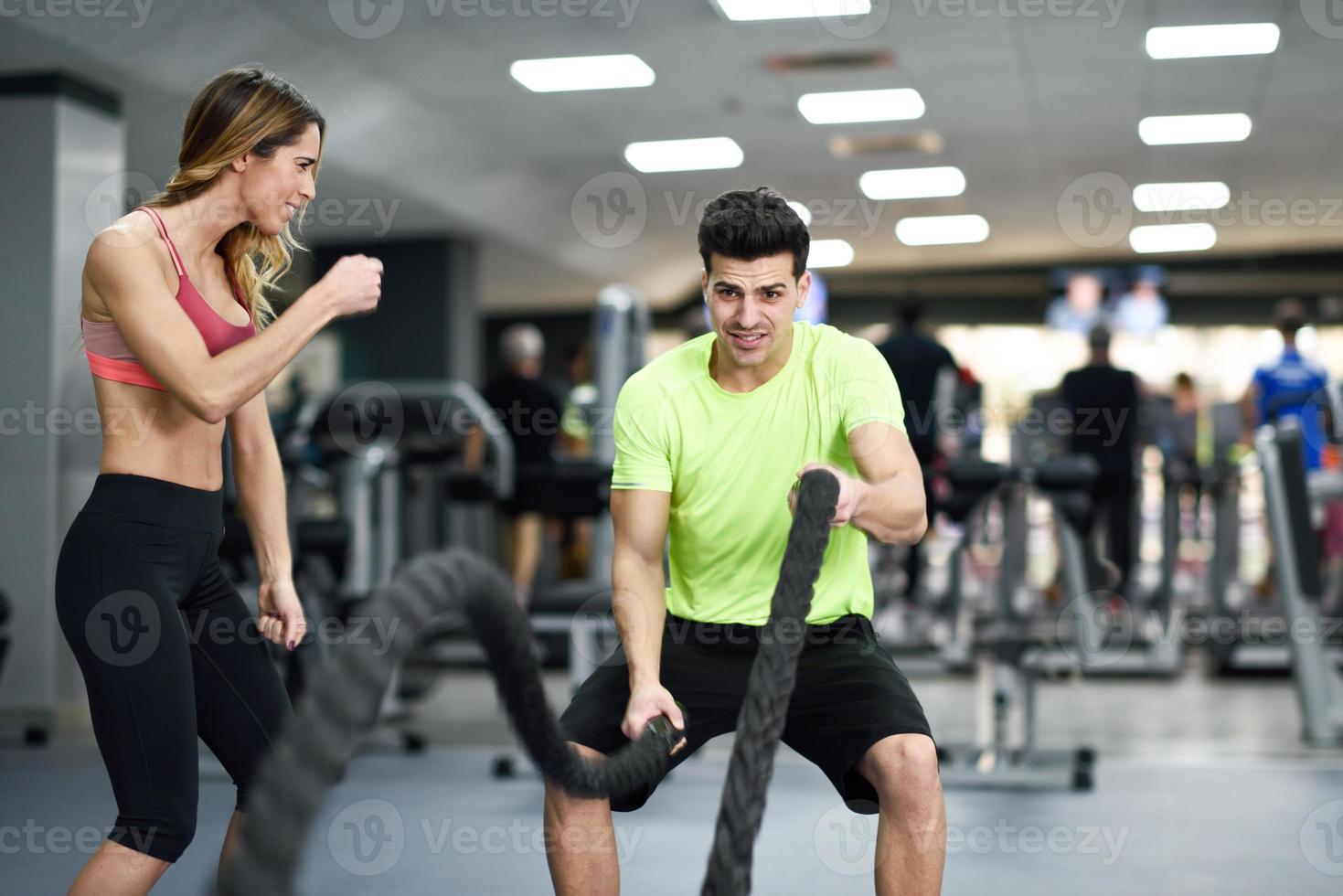 Mann mit Kampfseilen trainiert im Fitnessstudio. foto