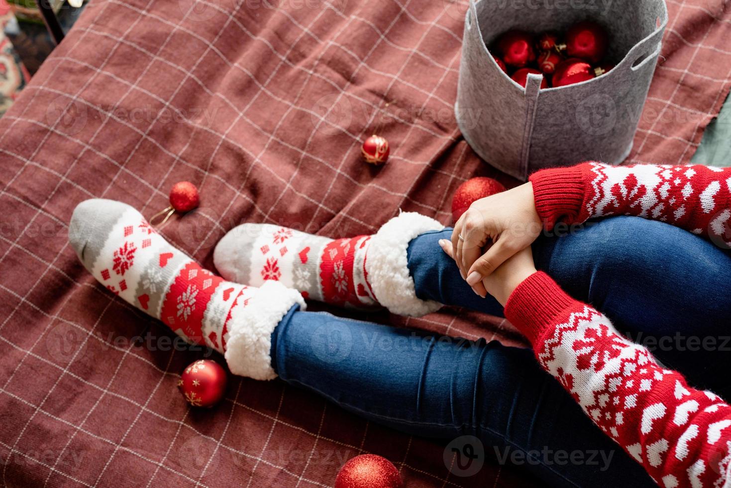 Draufsicht weibliche Beine mit Weihnachtssocken auf dem Bett mit Dekorationen foto