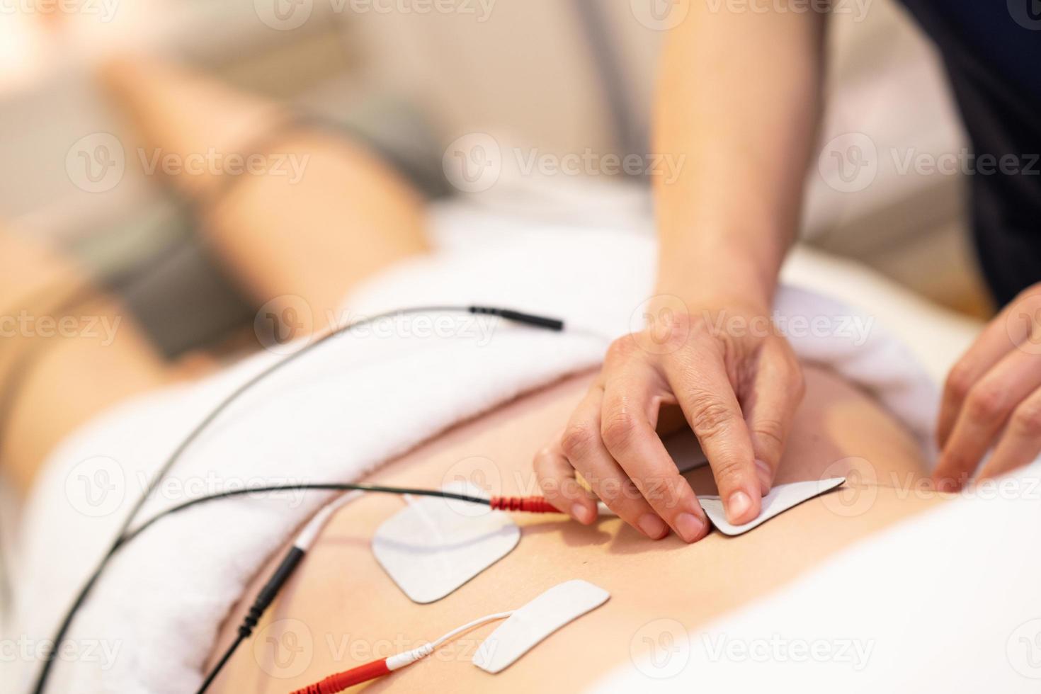 Elektrostimulation in der Physiotherapie bei einer jungen Frau foto