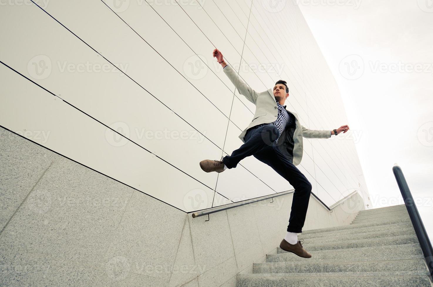 Mann, Model der Mode, springt und trägt Jacke und Hemd foto