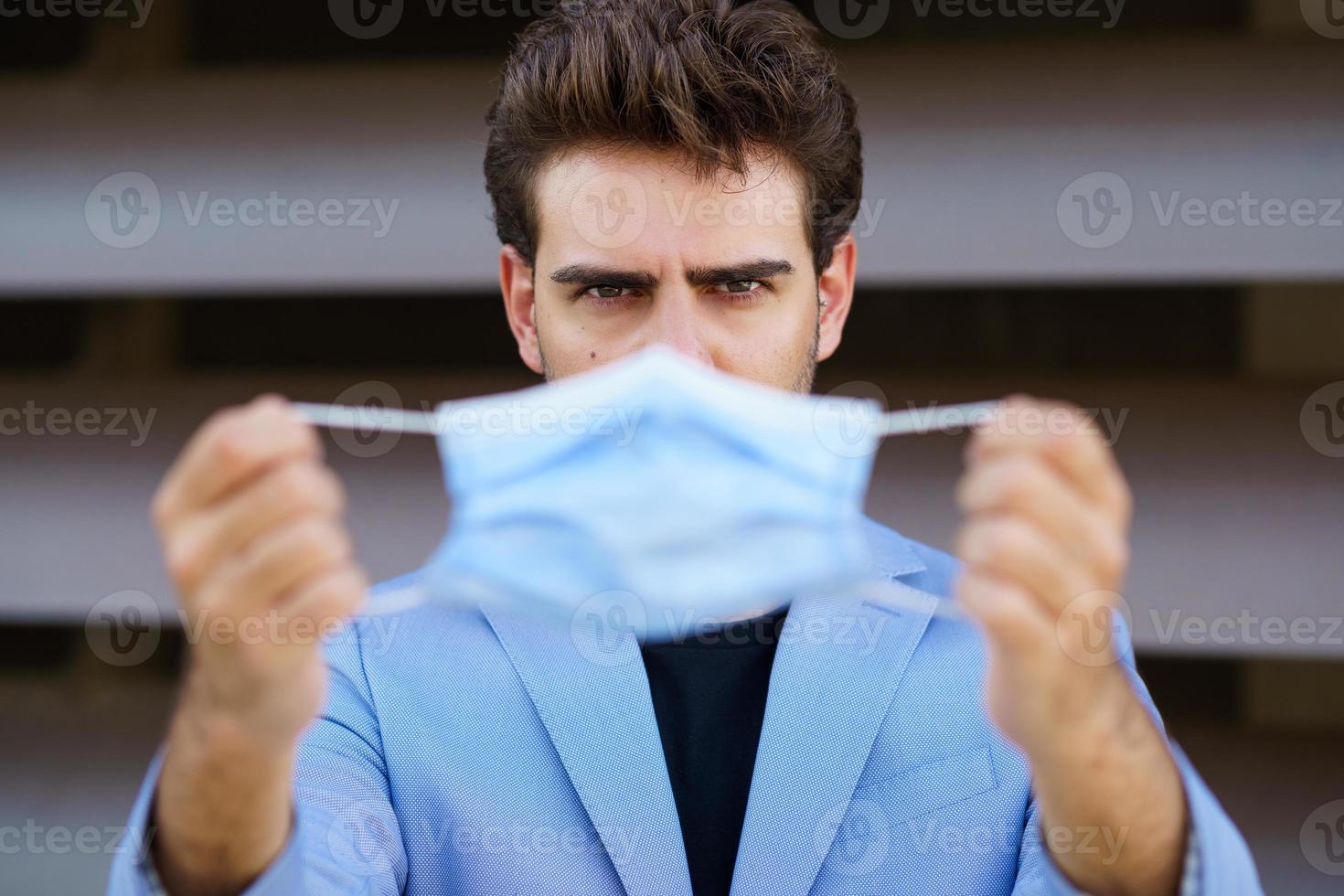 Geschäftsmann, der eine chirurgische Maske zum Schutz vor dem Coronavirus aufsetzt. foto