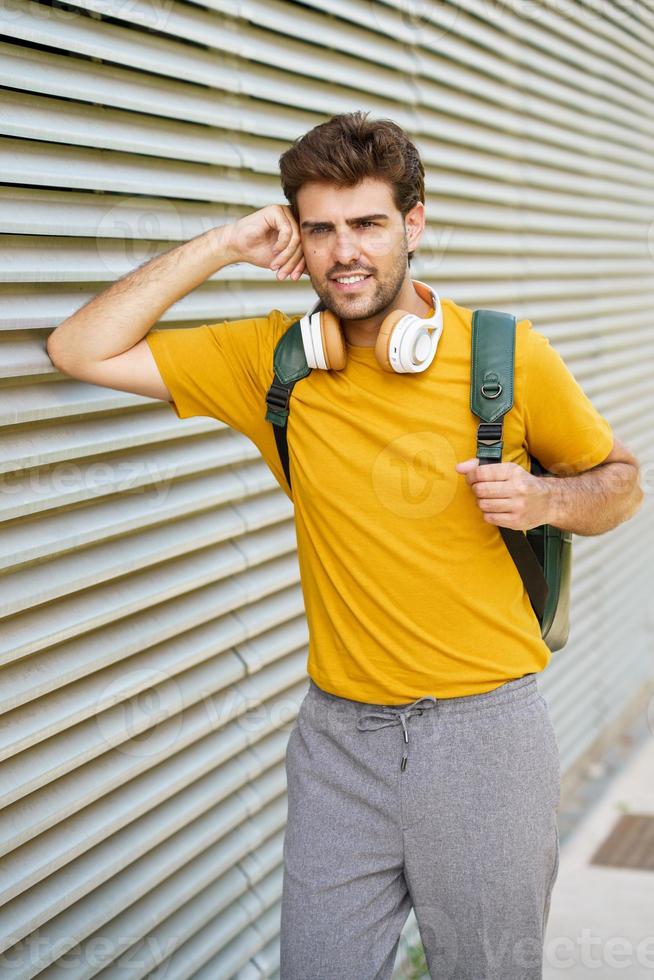 junger Mann mit Kopfhörern im städtischen Hintergrund foto
