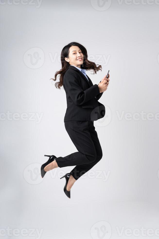 Ganzkörperbild der schönen jungen asiatischen Geschäftsfrau, isoliert auf weißem Hintergrund foto