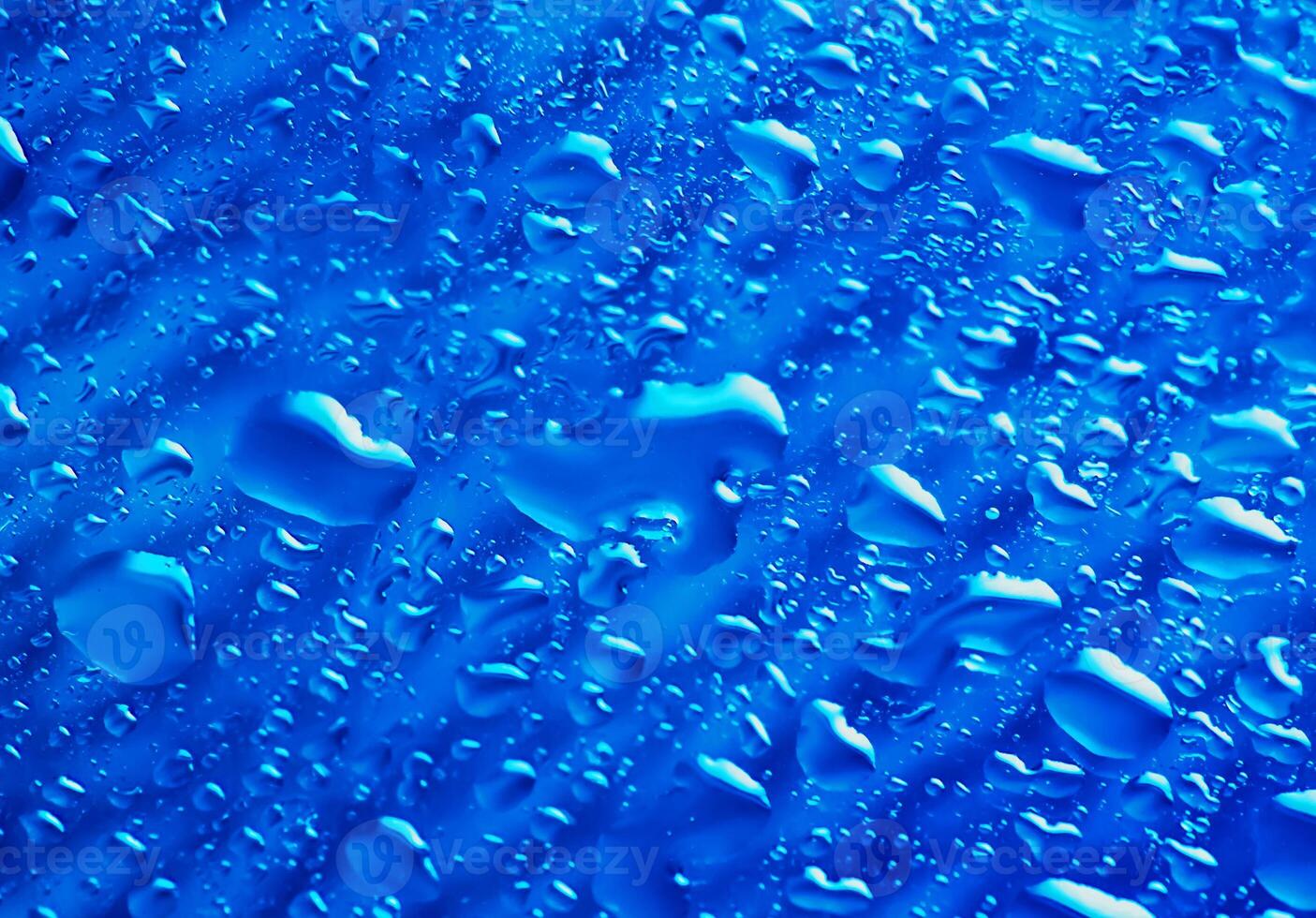 blaue transparente Wasserwellenspritzenzusammenfassung mit Wasserblasen auf Blau. foto