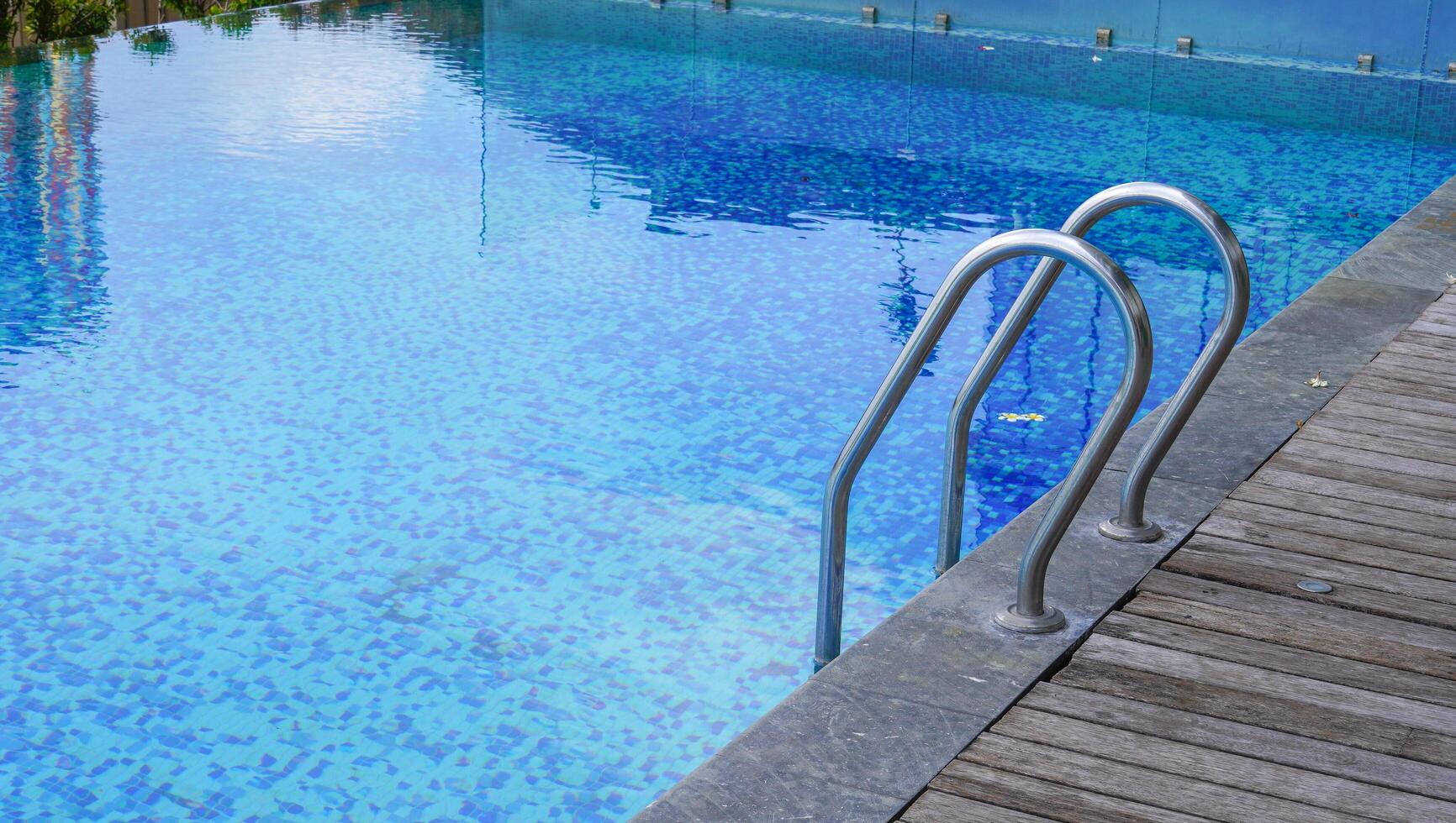 ein Schwimmbad mit klarem Wasser und einem Handlauf am Rand. Urlaub mit Schwimmen und Sommerkonzept genießen. ein öffentliches Schwimmbad. foto