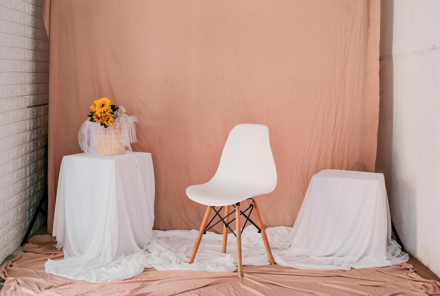 das studio ist mit wänden, tischen ausgestattet und der boden ist mit stoff ausgelegt. Einrichtung im Thema rosa-orange und weiß. foto