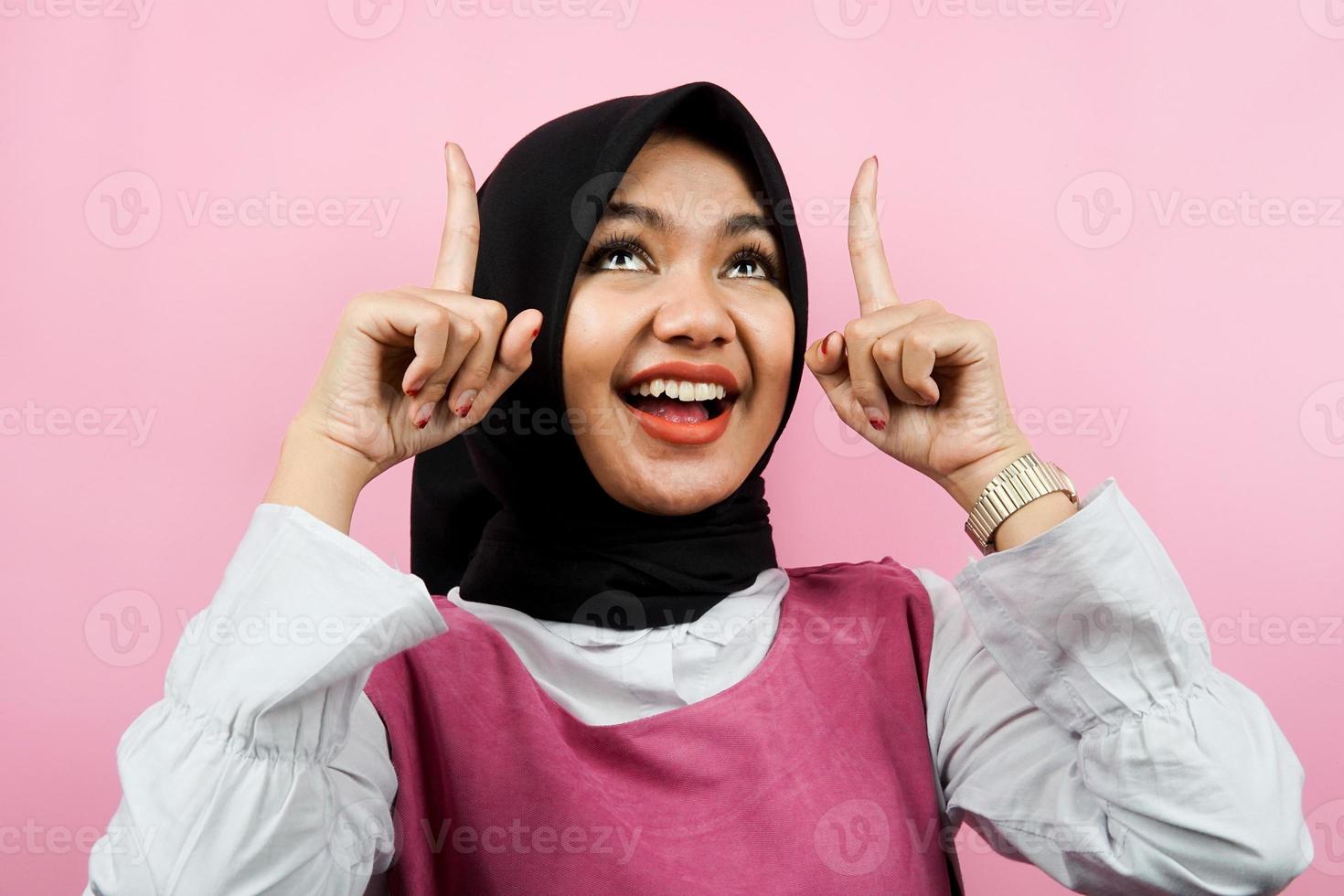 Nahaufnahme einer schönen jungen muslimischen Frau, die nach oben zeigt, isoliert foto