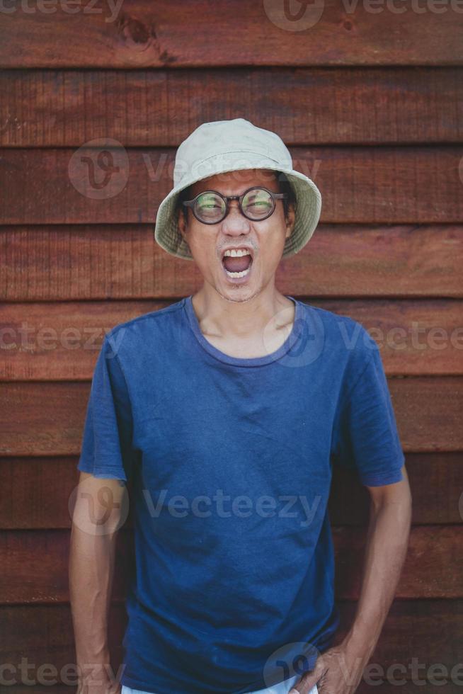 asiatischer Mann mit Kleidung, Hut, der mit lustigem Gesicht wow wirkt foto