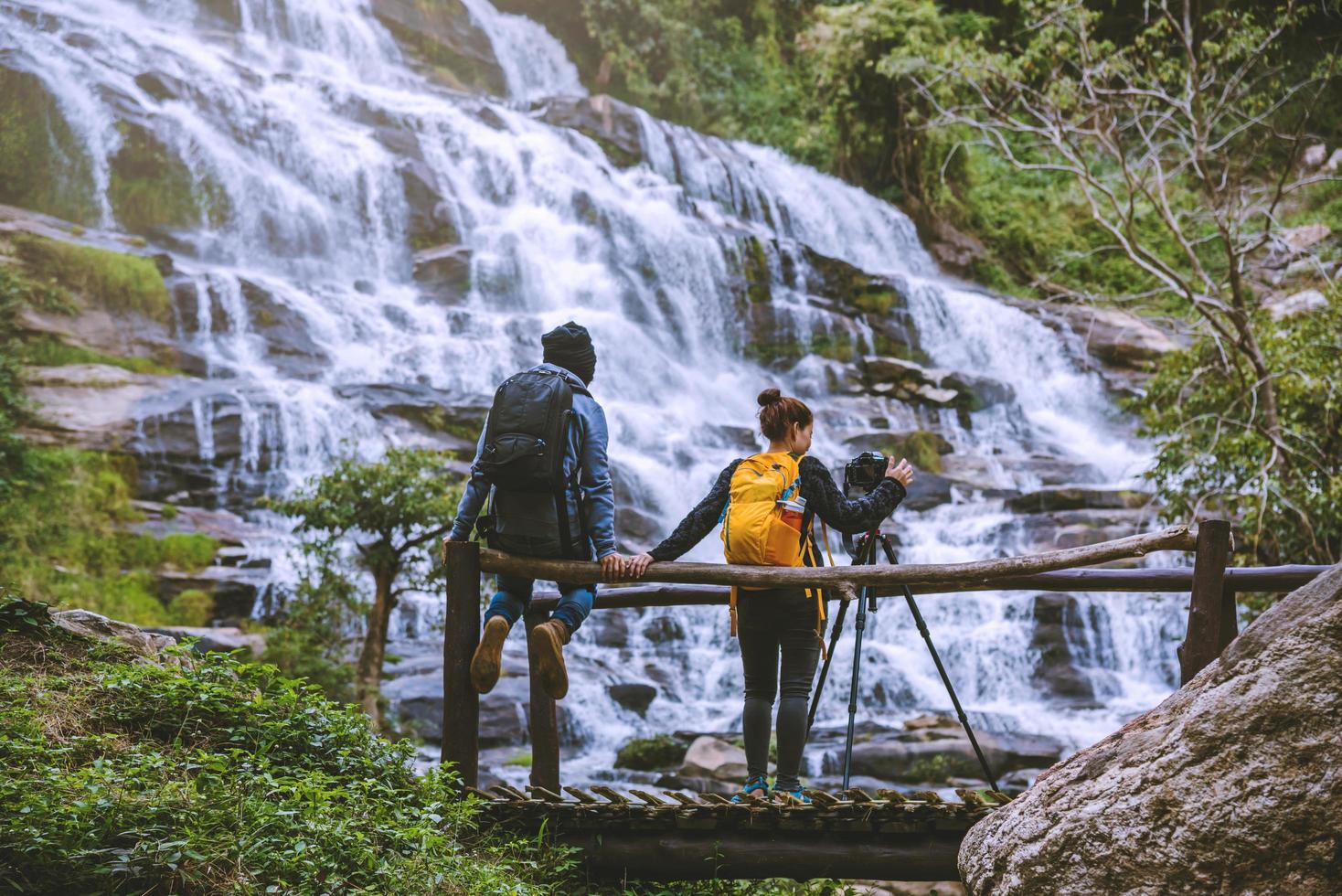 Paare reisen entspannt, um die schönen Wasserfälle zu fotografieren. im Winter. am wasserfall mae ya chiangmai in thailand. Natur reisen. Sommer foto