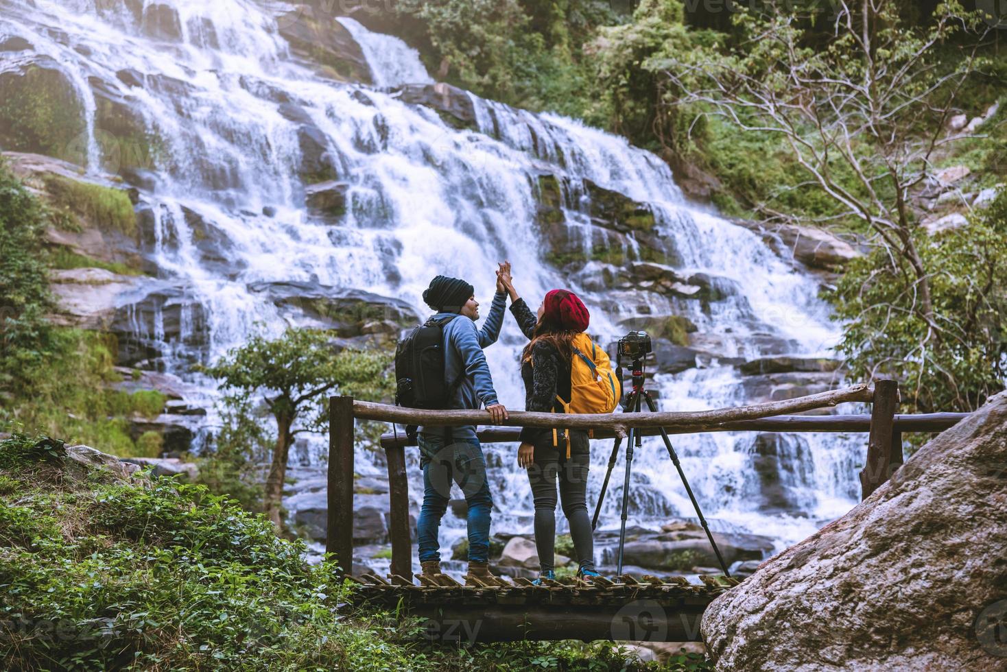 Paare reisen entspannt, um die schönen Wasserfälle zu fotografieren. im Winter. am wasserfall mae ya chiangmai in thailand. Natur reisen. Sommer foto