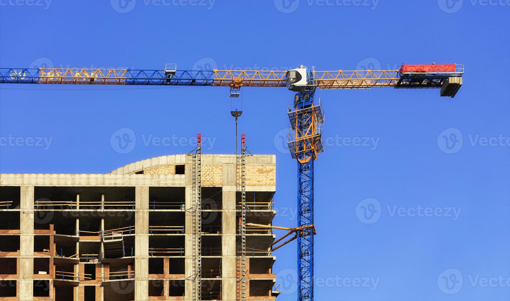 Fassade und Baukran in der Nähe des modernen Betongebäudes im Bau. foto